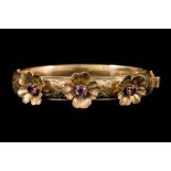 A 9CT YELLOW GOLD AMETHYST SET BANGLE, chased and engraved decoration.