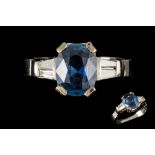 A SAPPHIRE RING, the oval sapphire to diamond shoulders,