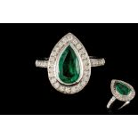 AN EMERALD AND DIAMOND CLUSTER RING, the pear shaped emerald to a diamond surround,