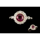 A RUBY AND DIAMOND ROUND CLUSTER RING, one round cut Burmese ruby of 1.