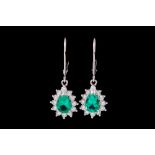 A PAIR OF EMERALD AND DIAMOND CLUSTER EARRINGS, of pear form, mounted in white gold.