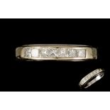 AN 18CT WHITE GOLD DIAMOND CHANNEL SET HALF HOOP RING, set with seven princess cut diamonds, size P,