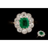 AN EMERALD AND DIAMOND CLUSTER RING, the octagonal cut emerald weighing 1.