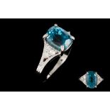 A BLUE ZIRCON AND DIAMOND DRESS RING, the oval cut blue zircon of approximately 5.