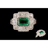 AN EMERALD AND DIAMOND CLUSTER RING, the rectangular cut emerald weighing 0.