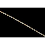 A DIAMOND LINE BRACELET, the brilliant cut diamonds channel set in white and yellow gold.