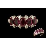 A RUBY AND DIAMOND CARVED DRESS RING, with oval cut rubies of 4.