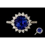 A DIAMOND AND TANZANITE CLUSTER RING, the circular tanzanite to a brilliant cut diamond surround,