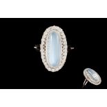 A MOONSTONE AND DIAMOND CLUSTER RING, the oval cabochon moonstone of approximately 8.