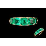 A FINE VICTORIAN FIVE STONE RING, set with trap cut emeralds,
