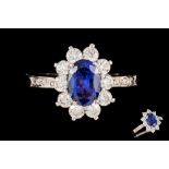 A SAPPHIRE AND DIAMOND CLUSTER RING SIGNED TIFFANY & CO, the oval cut sapphire of approximately 1.