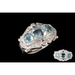 AN AQUAMARINE AND DIAMOND DRESS RING, three aquamarines of approx 3.