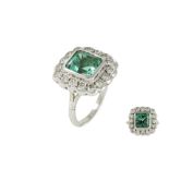 AN EMERALD AND DIAMOND CLUSTER RING, mounted in white gold, the emerald estimated to weigh 3.