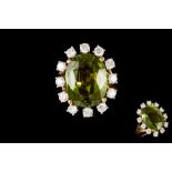 A PERIDOT AND DIAMOND OVAL CLUSTER RING,