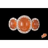 AN ORANGE GEM AND DIAMOND SET RING,