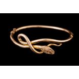 A 9CT GOLD COILED SNAKE MOTIF BANGLE.