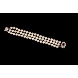 A THREE ROW CULTURED PEARL BRACELET WITH RUBY AND DIAMOND CLASP, one oval cut ruby of approx 1.