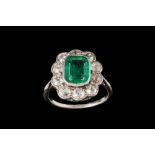 AN EMERALD AND DIAMOND CLUSTER RING