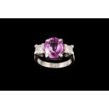 A PINK SAPPHIRE AND DIAMOND THREE STONE RING