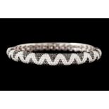 A DIAMOND PAVÉ HINGED BANGLE, set with black and white diamonds of 8.14ct, mounted in 18ct white