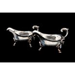 A PAIR OF LARGE GEORGE IV SILVER HELMET SHAPED PLAIN SAUCE BOATS, raised on three hoof feet,