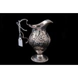 A VICTORIAN SILVER EMBOSSED MILK JUG, by John Grinsell & Son,