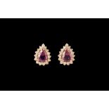 A PAIR OF PEAR SHAPED RUBY AND DIAMOND CLUSTER EARRINGS