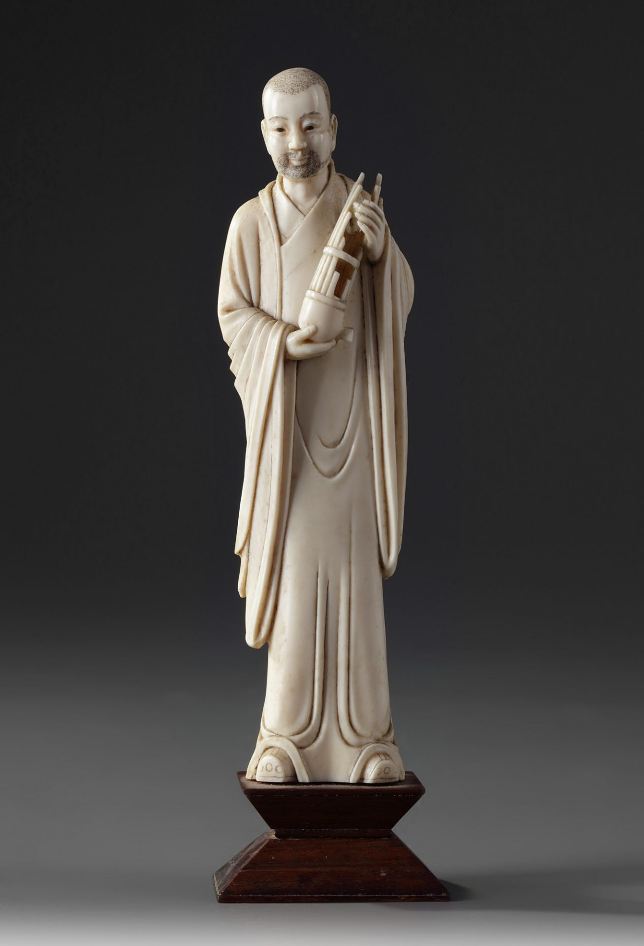 A Chinese ivory carving of a standing musician