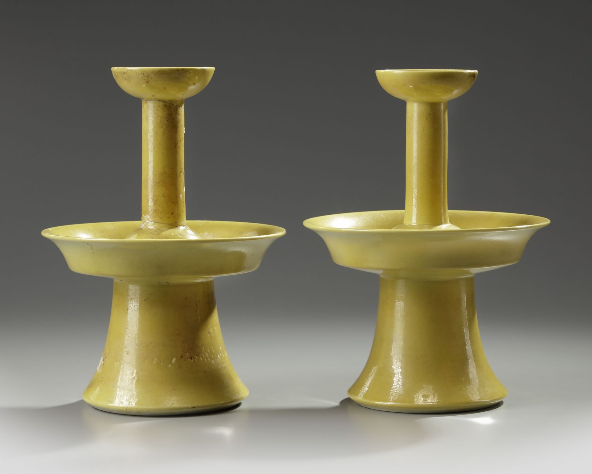 A pair of Chinese yellow-glazed candlestick holders