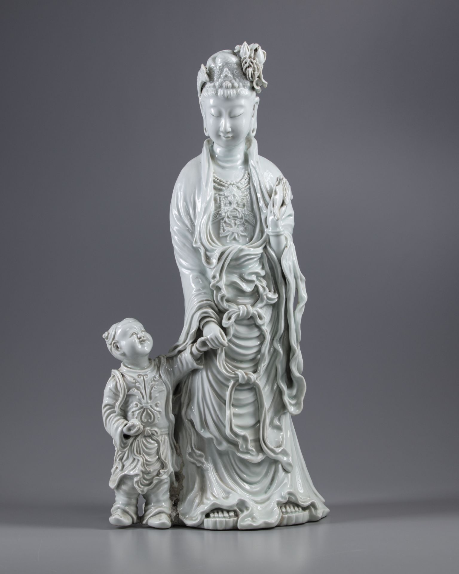 An exceptional large dehua glazed figure of Guanyin with child