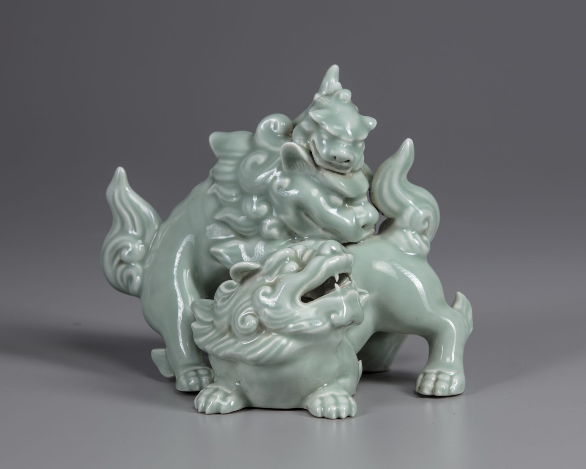 A Japanese celadon statue of two lions