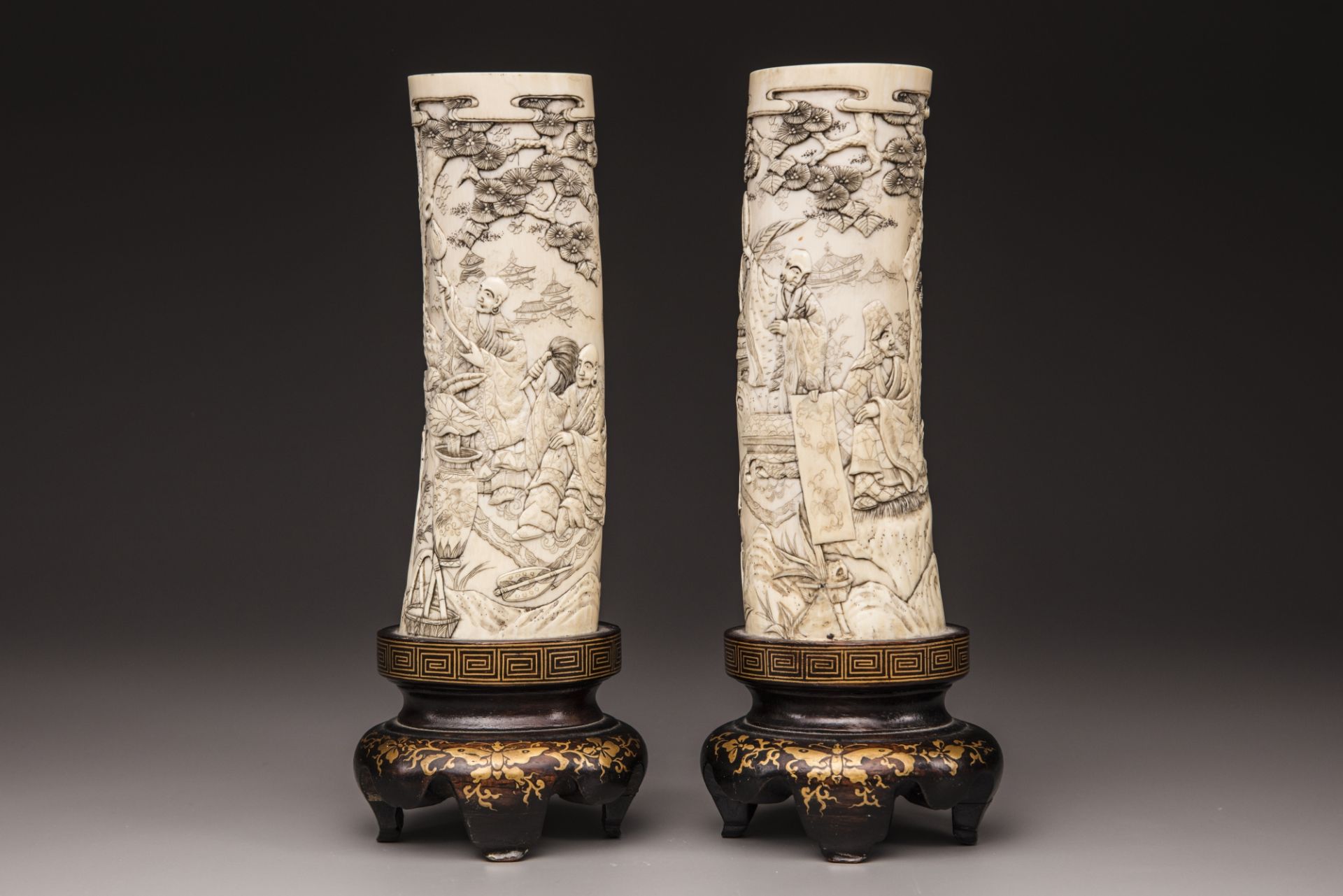 A pair of Japanese carved tusks with wooden base