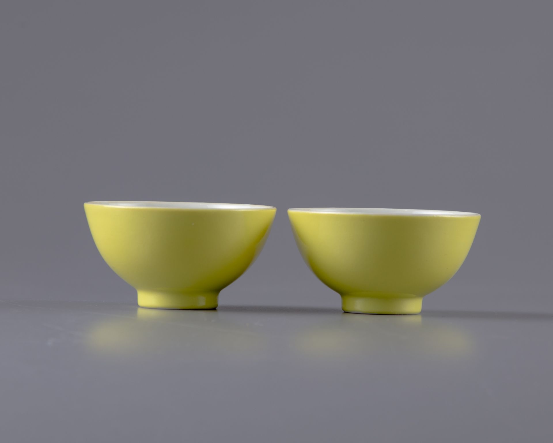 A pair of yellow-glazed cups