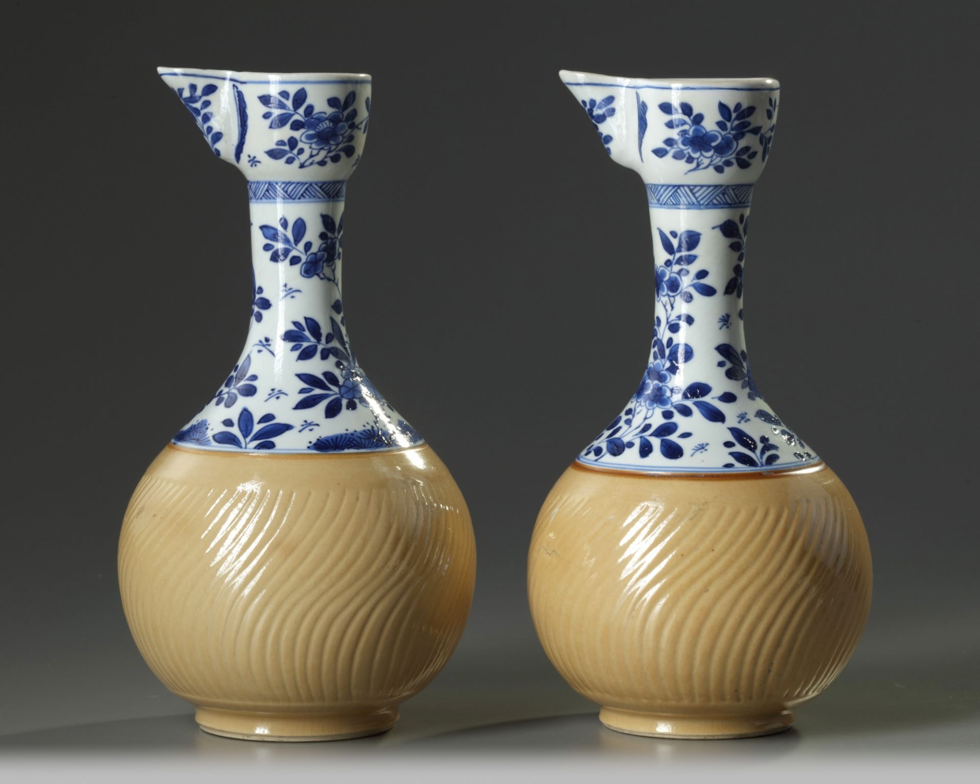 A pair of Chinese blue and white and cafe-au-lait glazed ewers