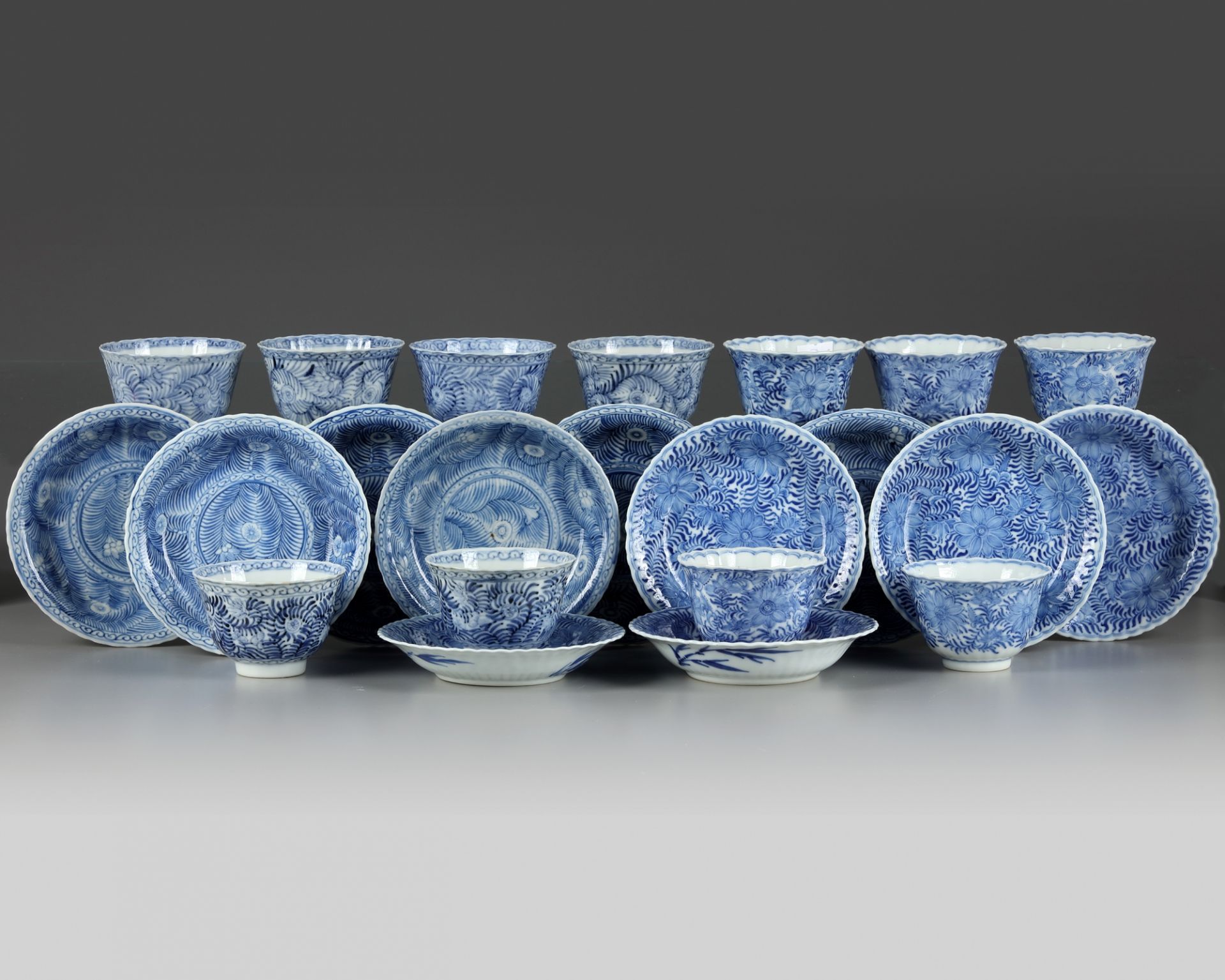 A set and a matched set of Chinese blue and white flower scroll cups and saucers