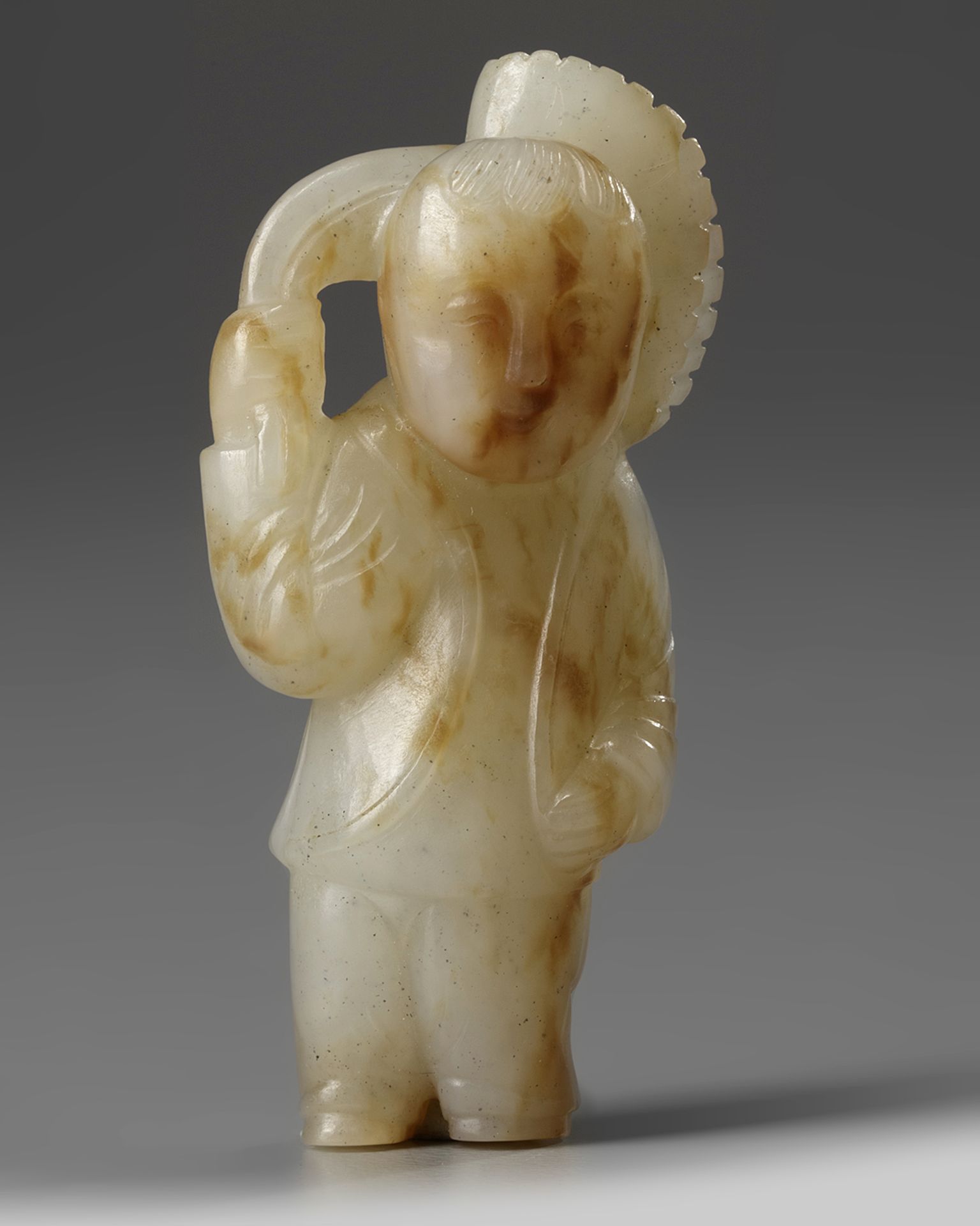 A Chinese pale celadon and russet 'boy' carving