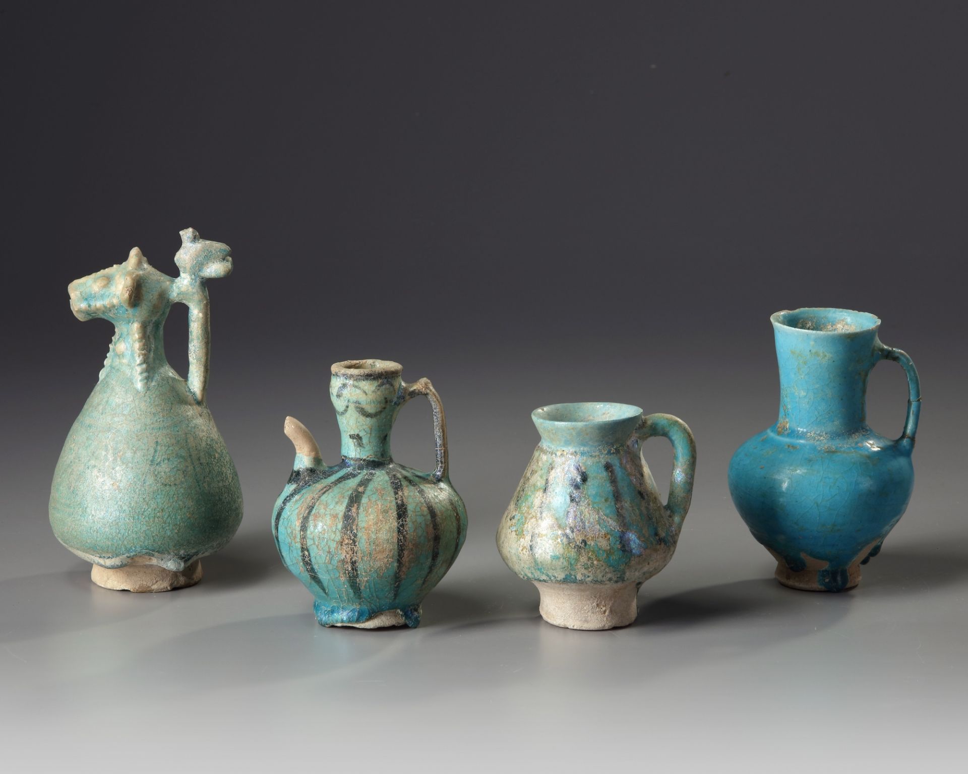 Four Islamic turquoise glazed jugs