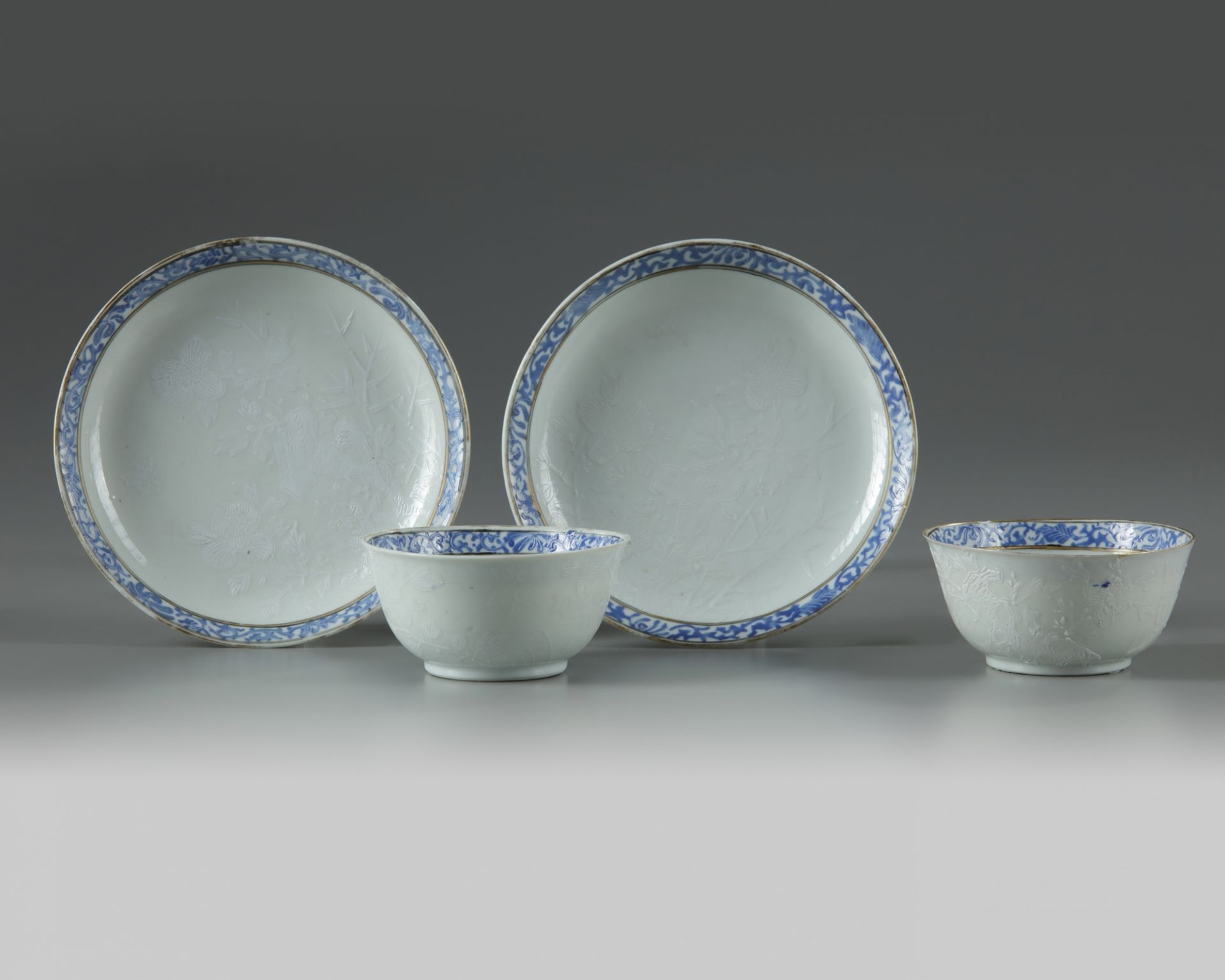 A pair of Chinese bianco sopra bianco-decorated cups and saucers