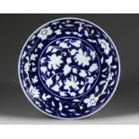 A Chinese reserve-decorated blue-ground 'floral' dish