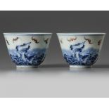 A pair of Chinese iron-red decorated blue and white ‘bats and waves’ cups