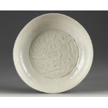 A Chinese white-glazed moulded ‘dragon’ dish