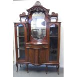 EDWARDIAN MAHOGANY SERPENTINE DISPLAY CABINET, having ornate carved floral,