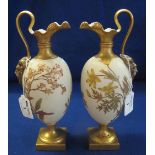 Pair of Royal Worcester ivory ground gilt decorated ewers, overall with foliage and flowers,