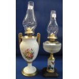 Brass single burner oil lamp with urn shaped ceramic body painted with flowers on a pedestal base