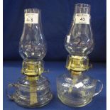 Two brass single burner chamber oil lamps with clear glass reservoirs and glass chimneys. (2) (B.P.