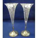 Pair of engraved glass flute vases with floral decoration, on circular silver bases.