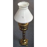 Large brass oil lamp with tall pedestal base, in Eastern style, having conical white glass chimney,