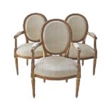 A set of three French Louis XVI style armchairs, carved gesso giltwood frames with oval backs.