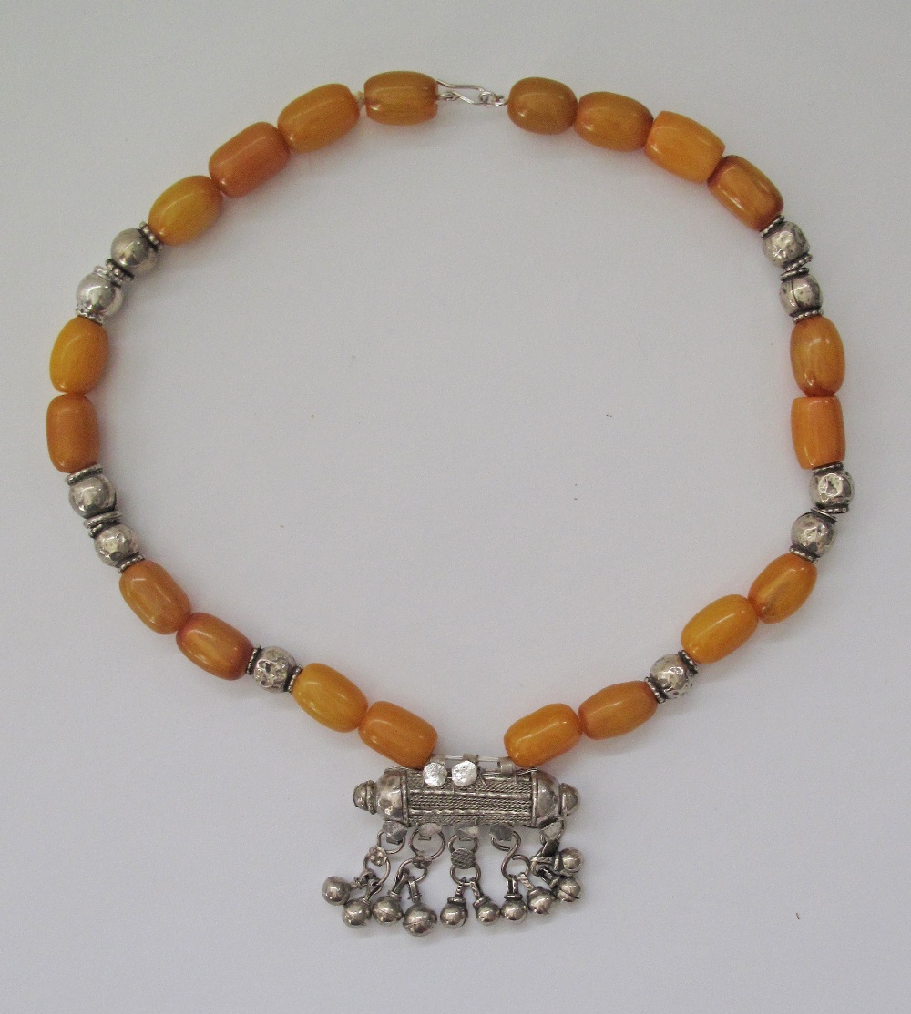 An amber and white metal necklace with a center pendant L60cm.