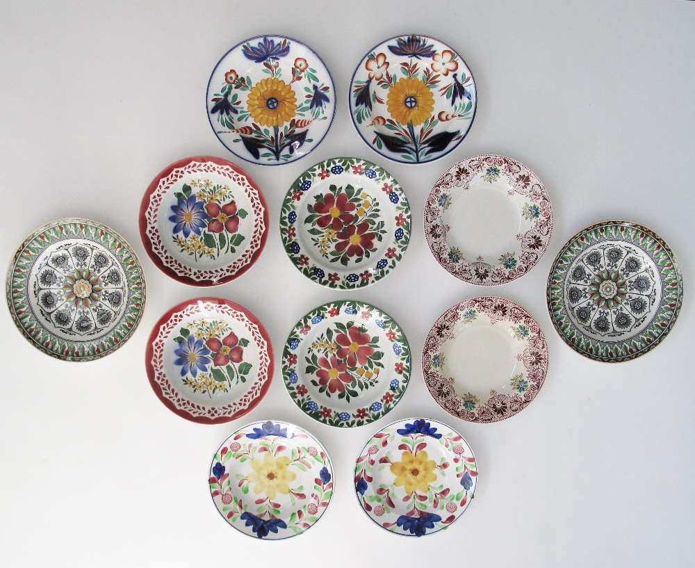 A collection of twelve antique Folk Art ceramic plates comprising six pairs of floral hand decorated